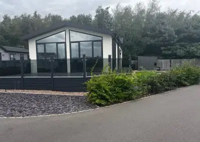 Modern residential park home with a stylish deck and landscaped garden at Gateforth Park