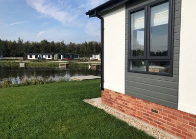 A house with a lake in the background in Omar Newmarket.